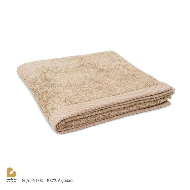 Toalha de banho bege dobrada em fundo branco