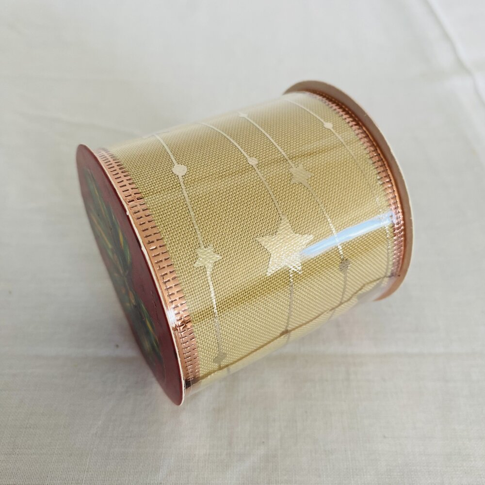 Rolo de fita decorativa bege com estrelas e bordas cobre
