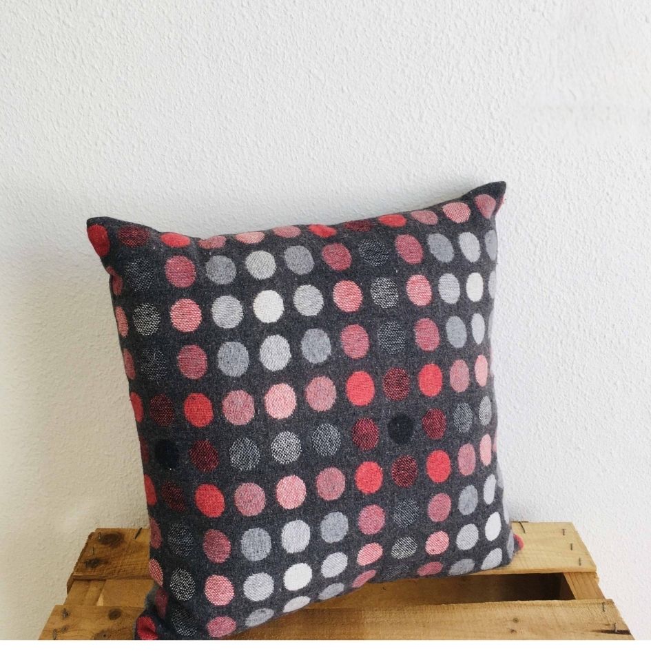 Almofada quadrada com padrão colorido num caixote de madeira