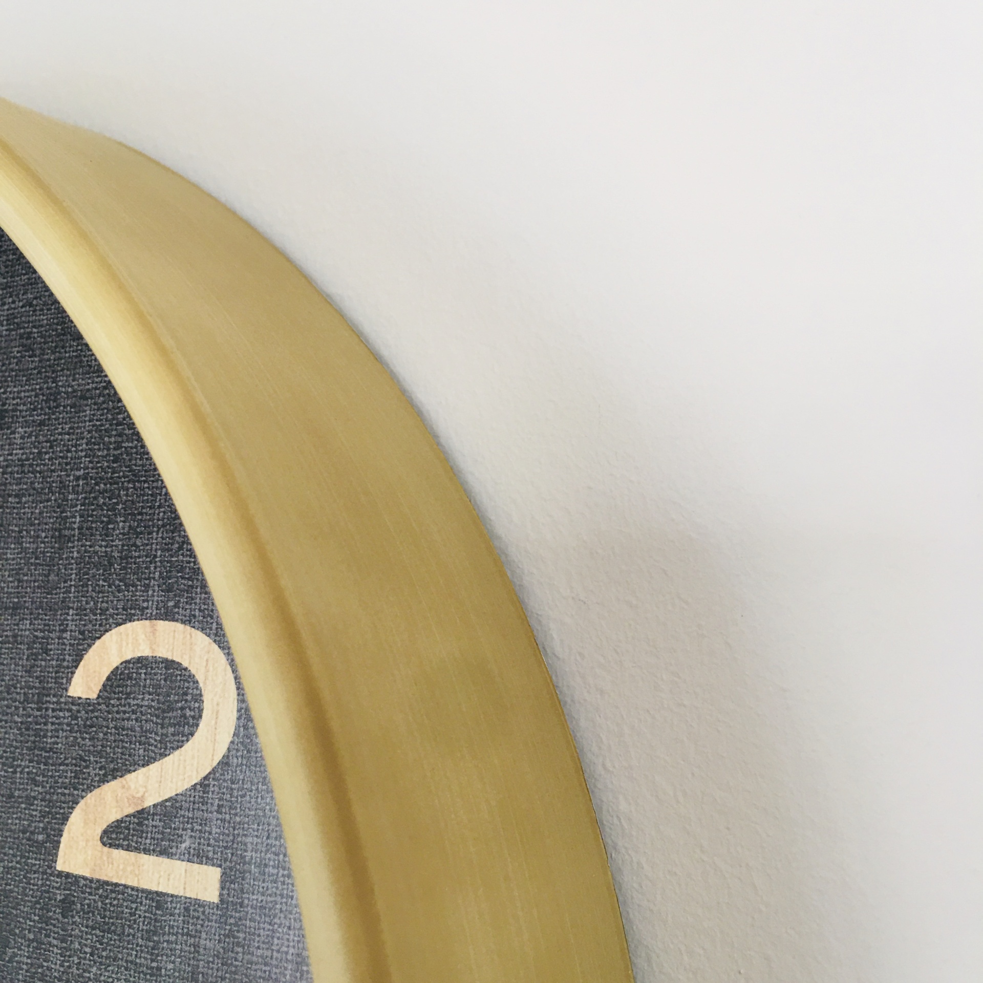 Relógio de parede com moldura dourada e mostrador preto texturizado