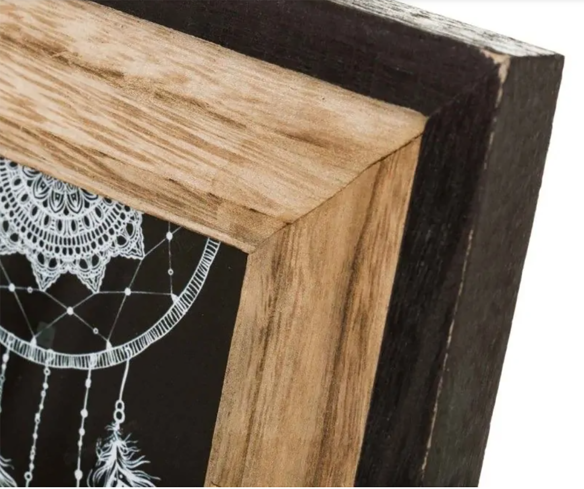 Canto de moldura de madeira com detalhe de desenho em fundo preto