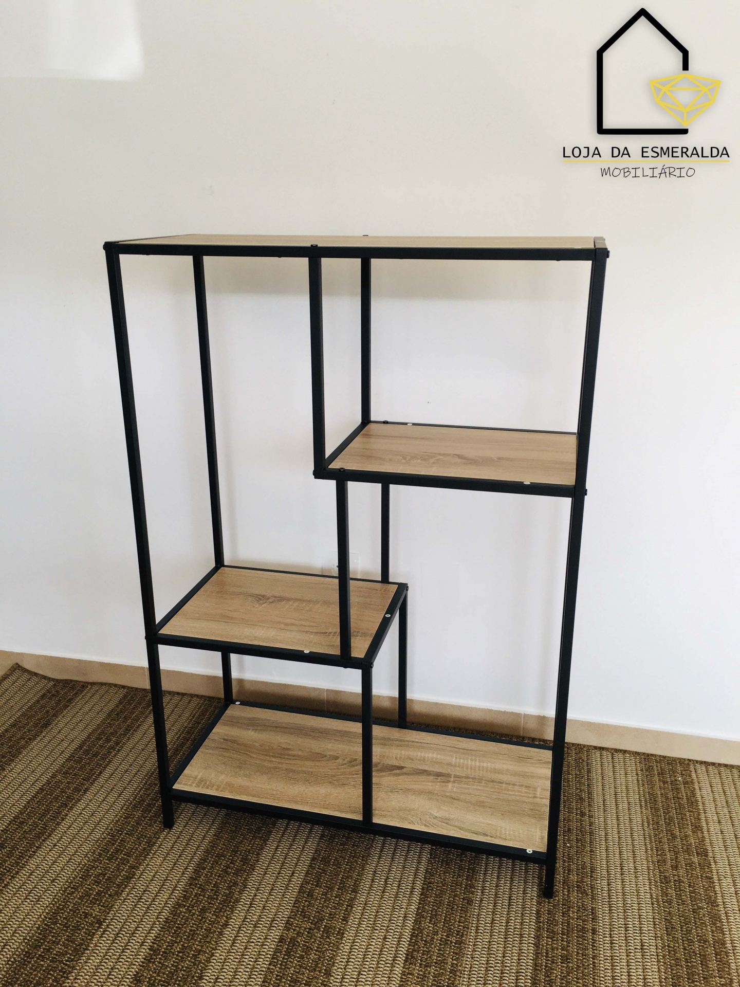 Estante de metal preto com prateleiras de madeira clara sobre tapete às riscas em zona interior