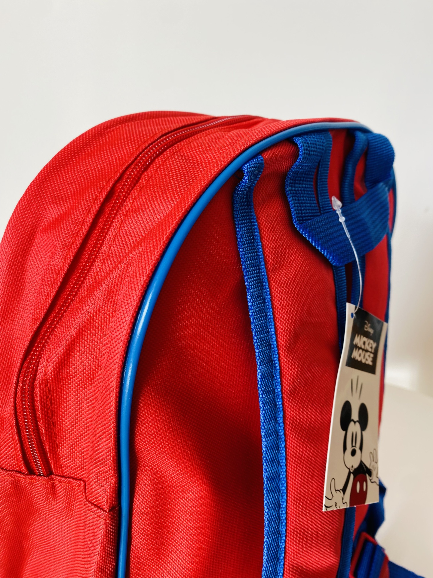 Mochila vermelha e azul com etiqueta de Mickey Mouse