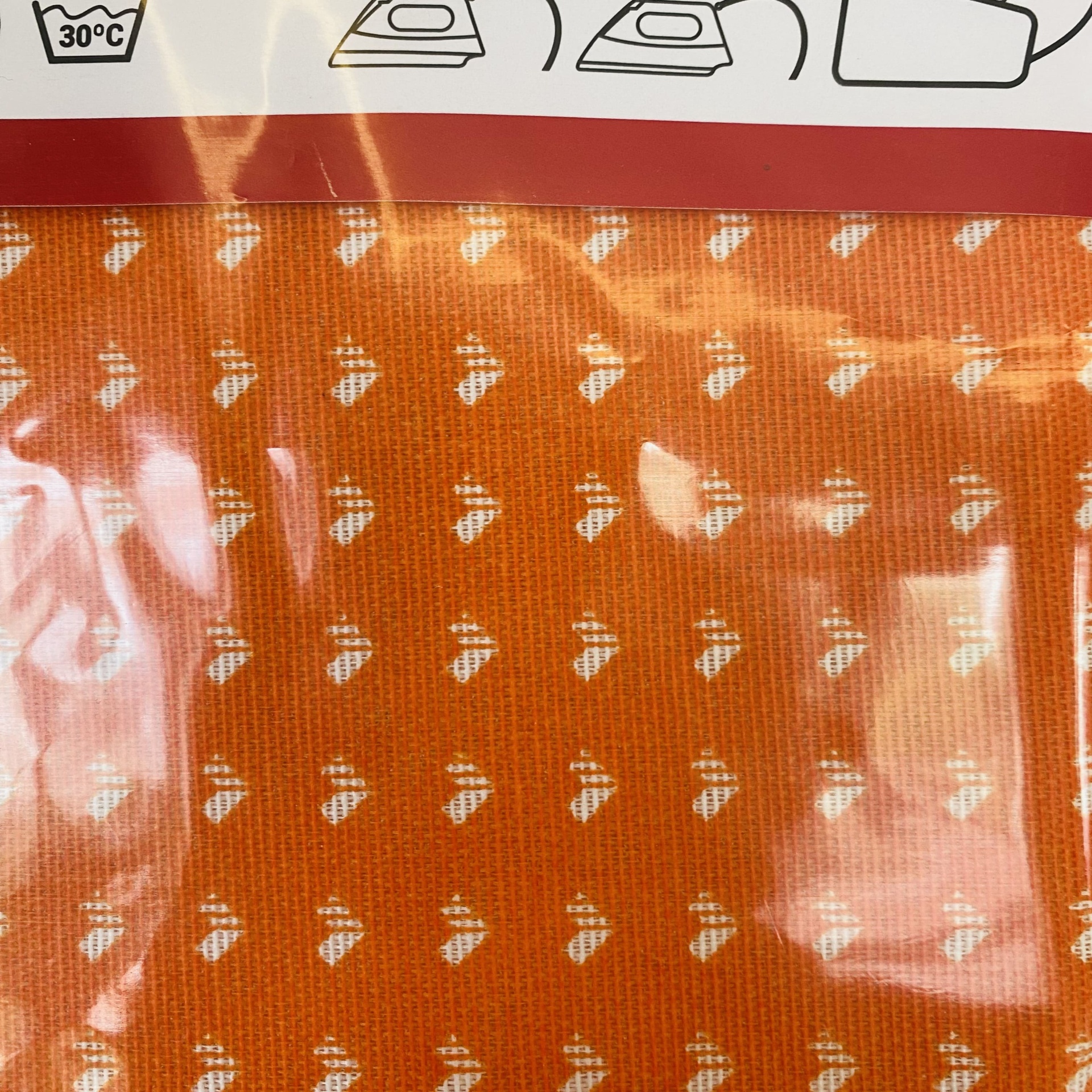 tecido laranja com padrão branco em embalagem transparente