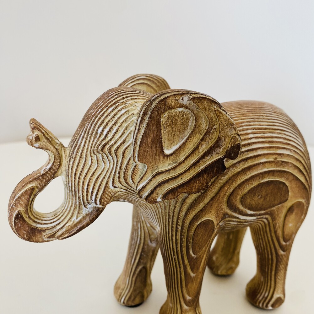 Estátua de elefante de madeira com textura ondulada castanha