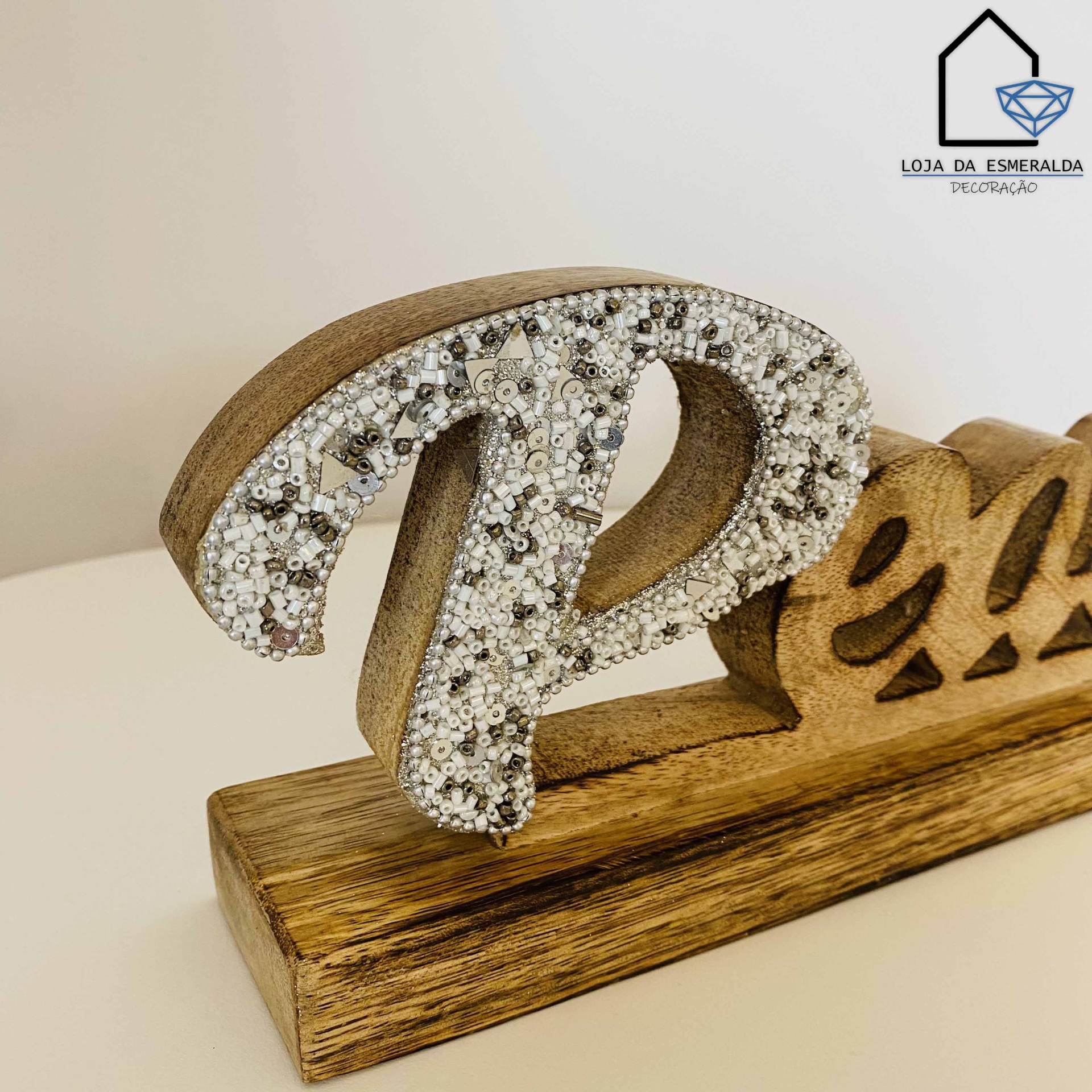 Objeto decorativo em madeira com a palavra Relax, letra R decorada com pérolas prateadas