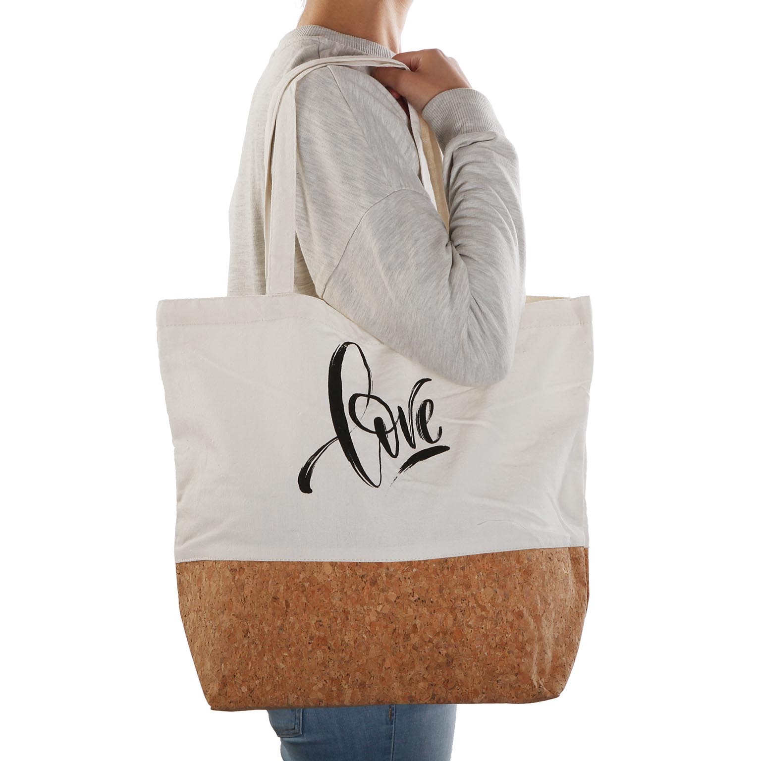 Saco tote branco com base em cortiça e a palavra 'love' em preto, levado ao ombro