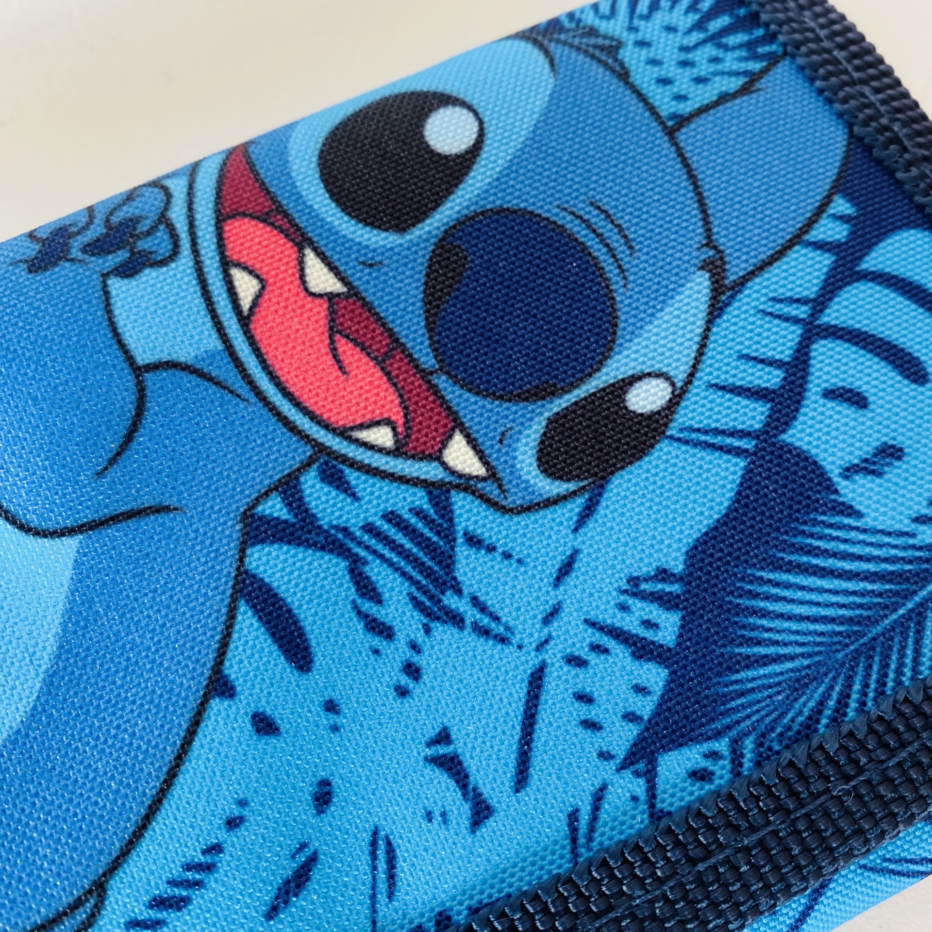 Tecido azul estampado com personagem de desenho animado e padrão de folhas