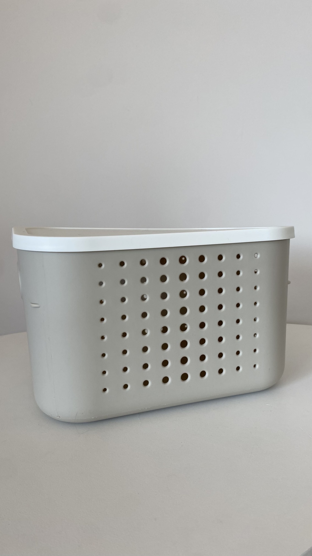 Cesto organizador cinza com tampa branca e furos circulares na lateral
