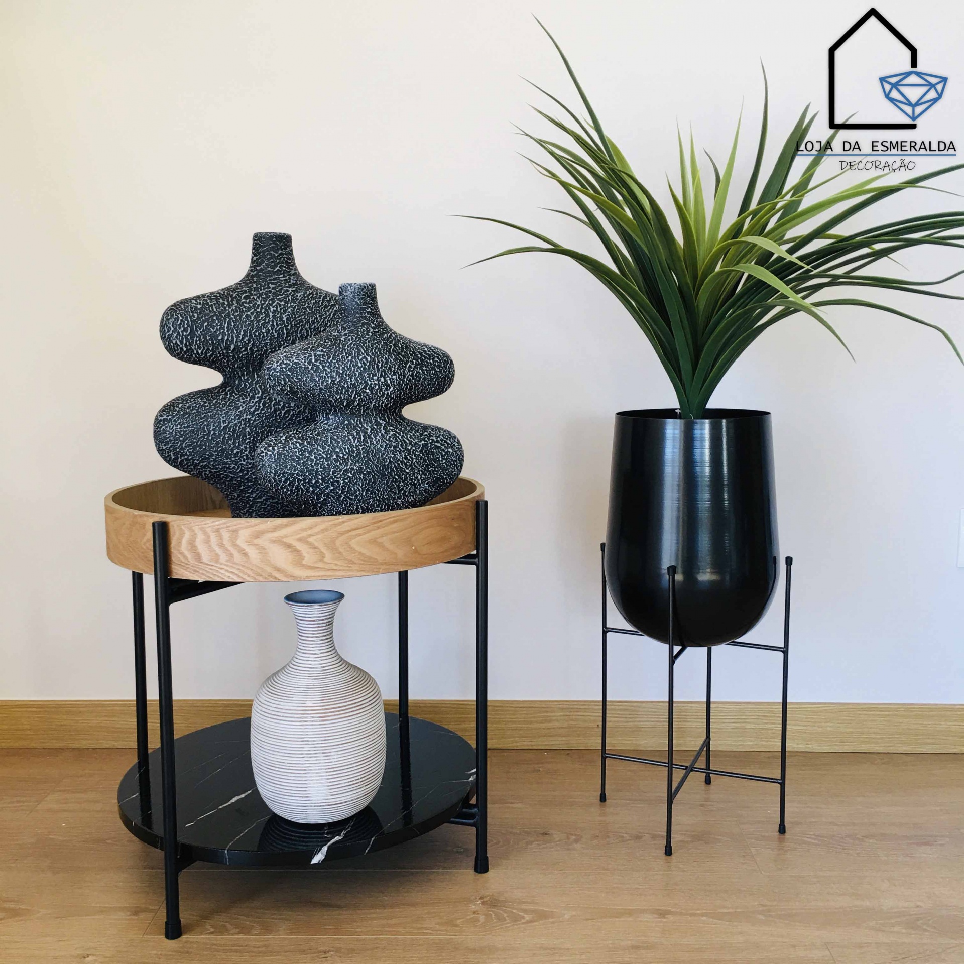 Vasos decorativos preto e branco com suporte de madeira e metal e vaso preto metálico com planta verde