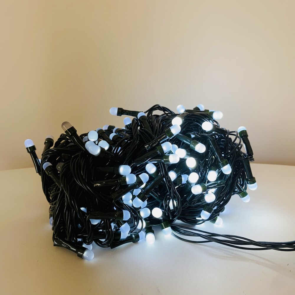 Cordão de luzes LED brancas com fio preto sobre uma superfície branca