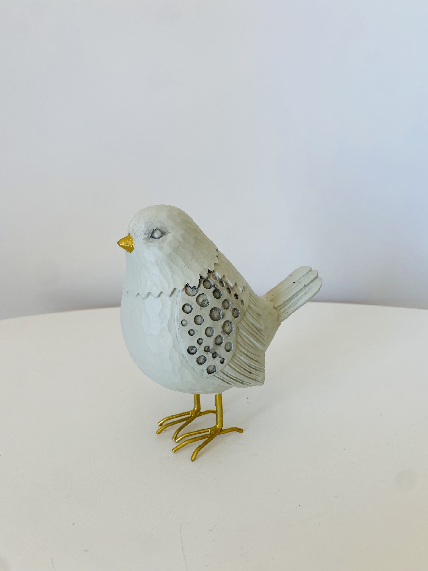 Figura decorativa de pássaro branco com bico e pernas douradas