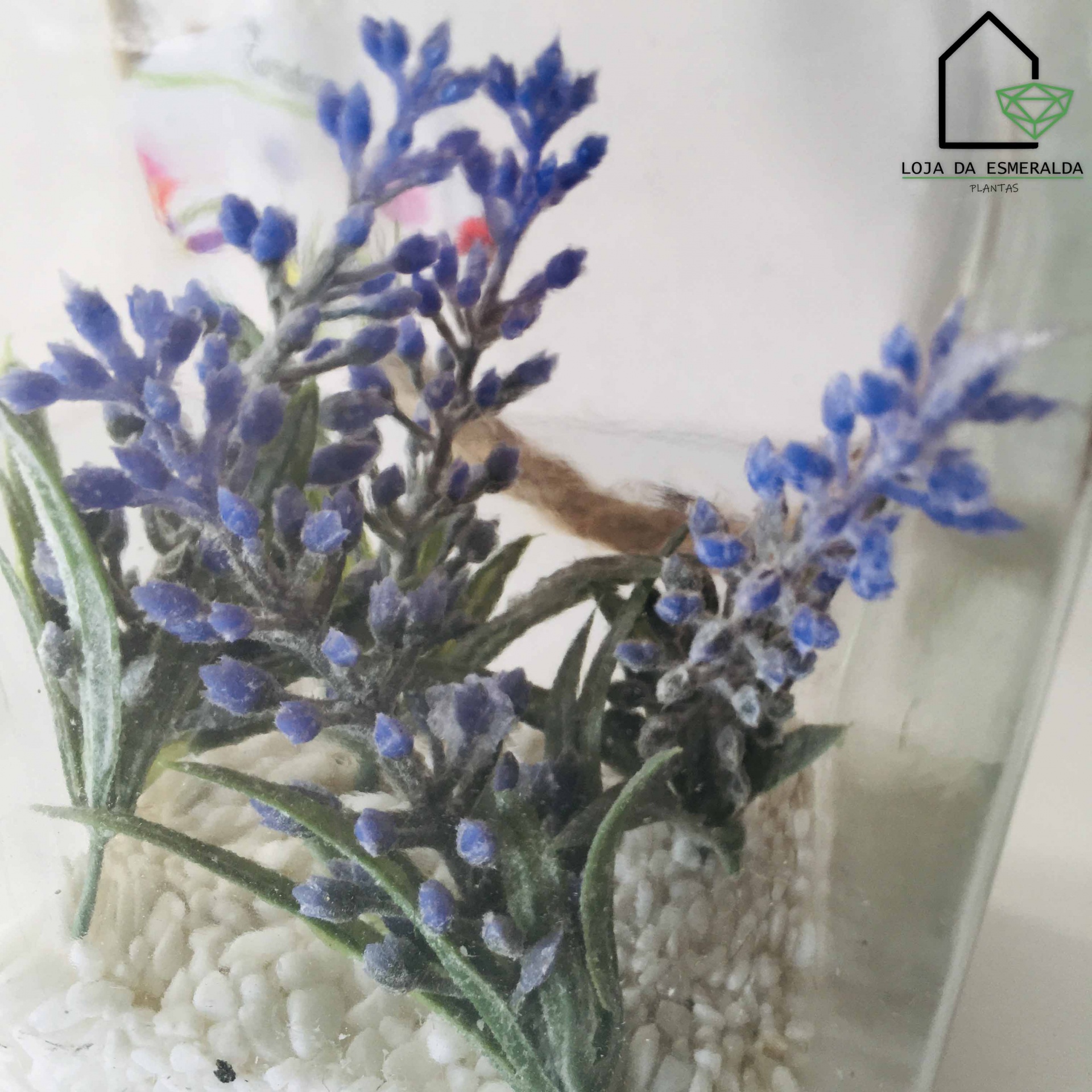 Flores artificiais roxas em vaso transparente com pedras brancas