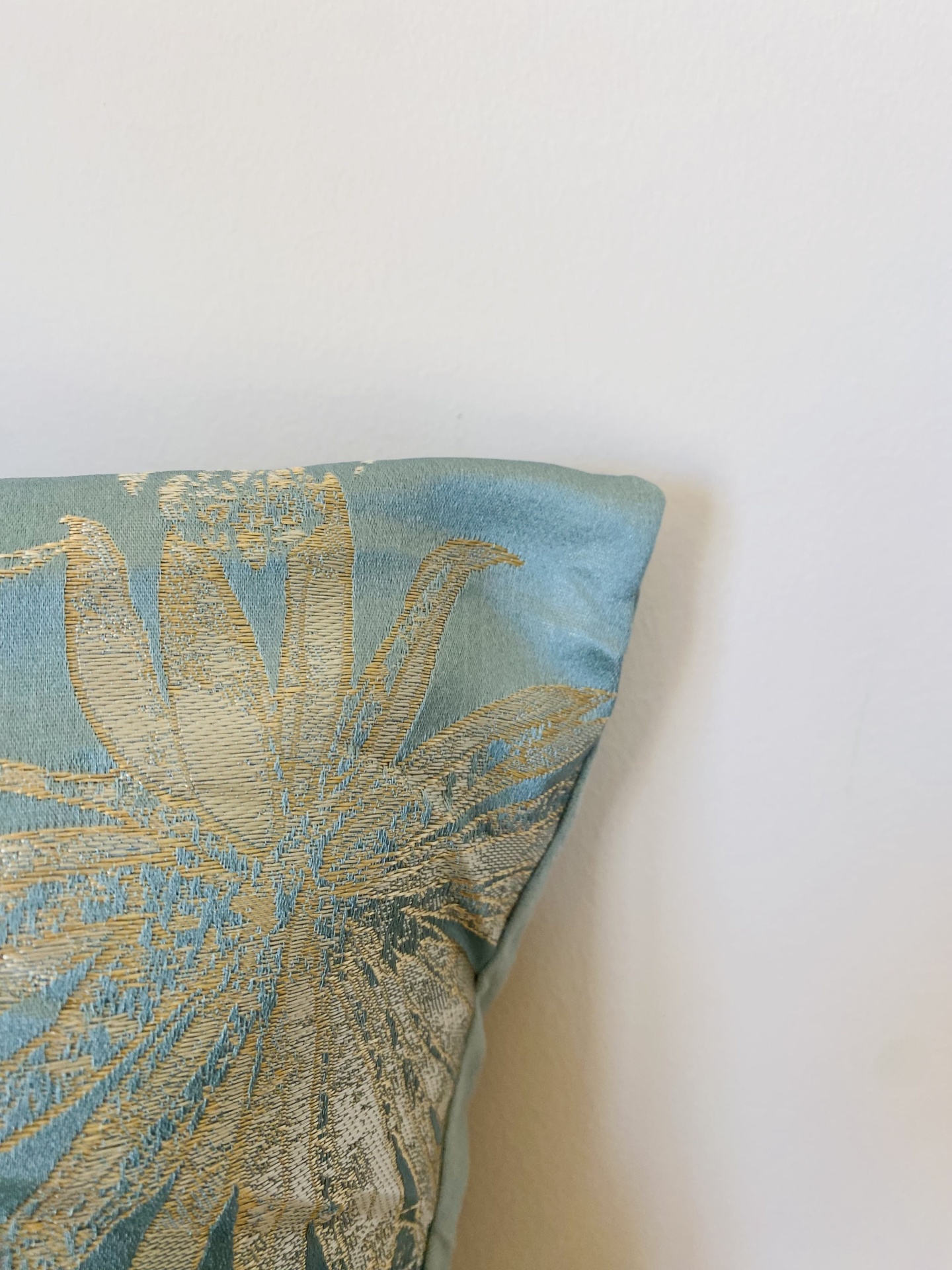 Almofada azul claro com padrão floral dourado