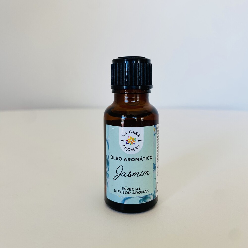 Frasco de óleo aromático de jasmim em vidro âmbar com tampa preta sobre superfície branca