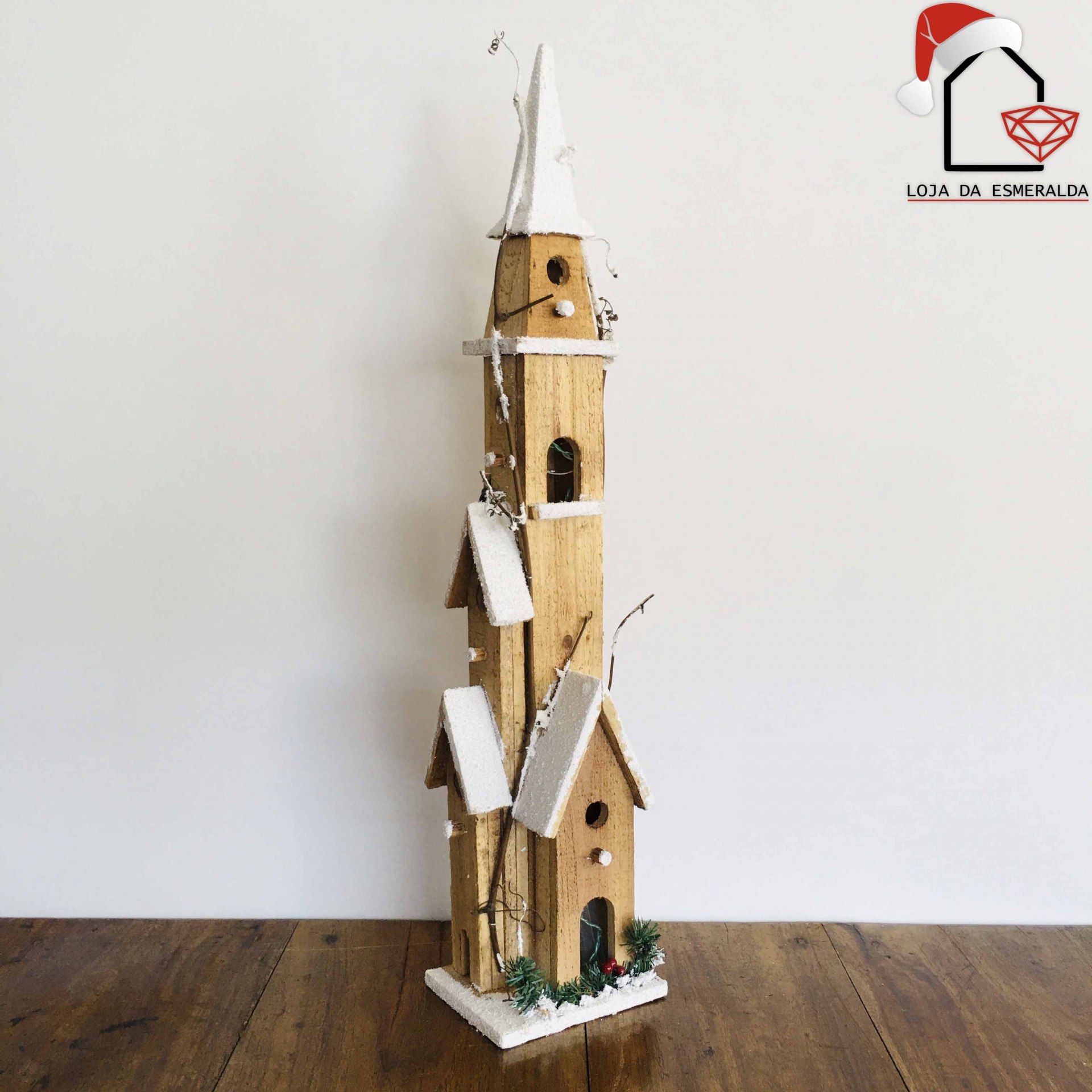 Casa decorativa de madeira com telhados brancos sobre superfície de madeira