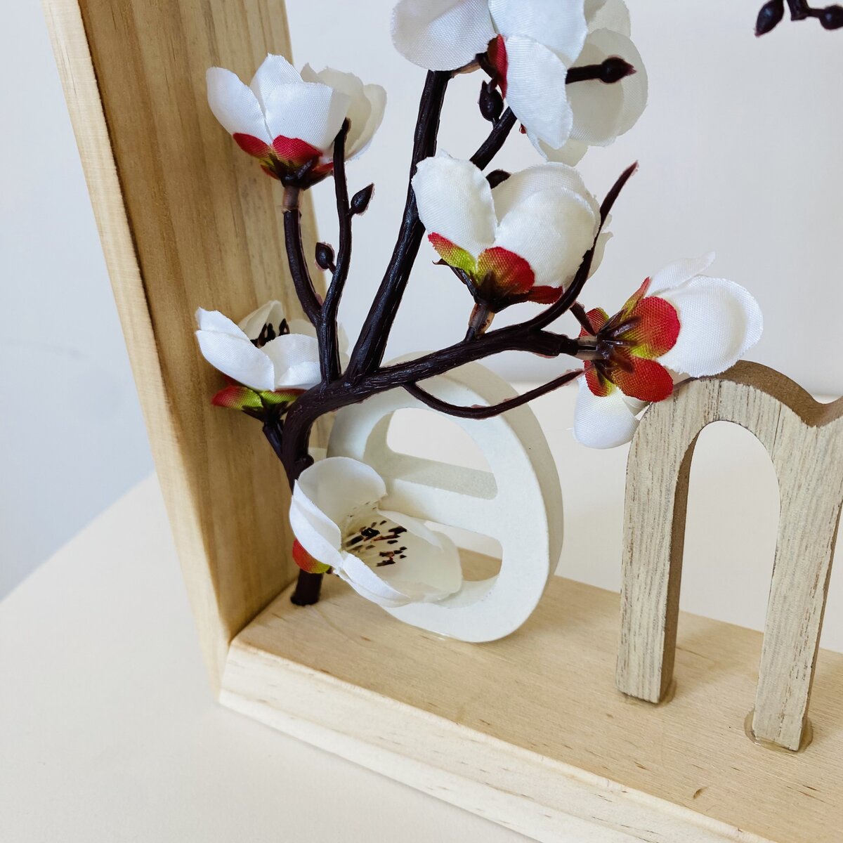 Arranjo decorativo em madeira com flores artificiais brancas e vermelhas