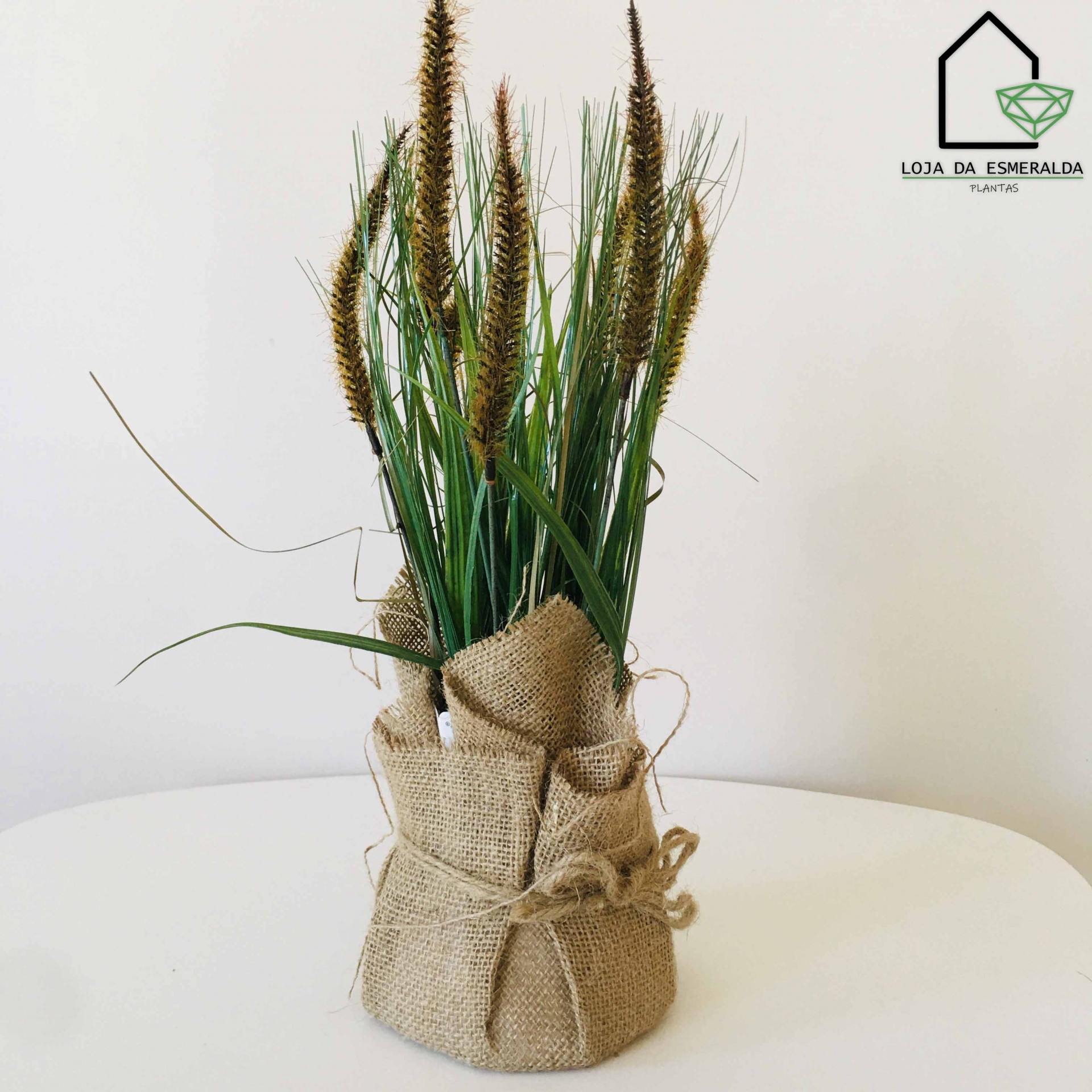 Arranjo de plantas artificiais em saco de juta amarrado