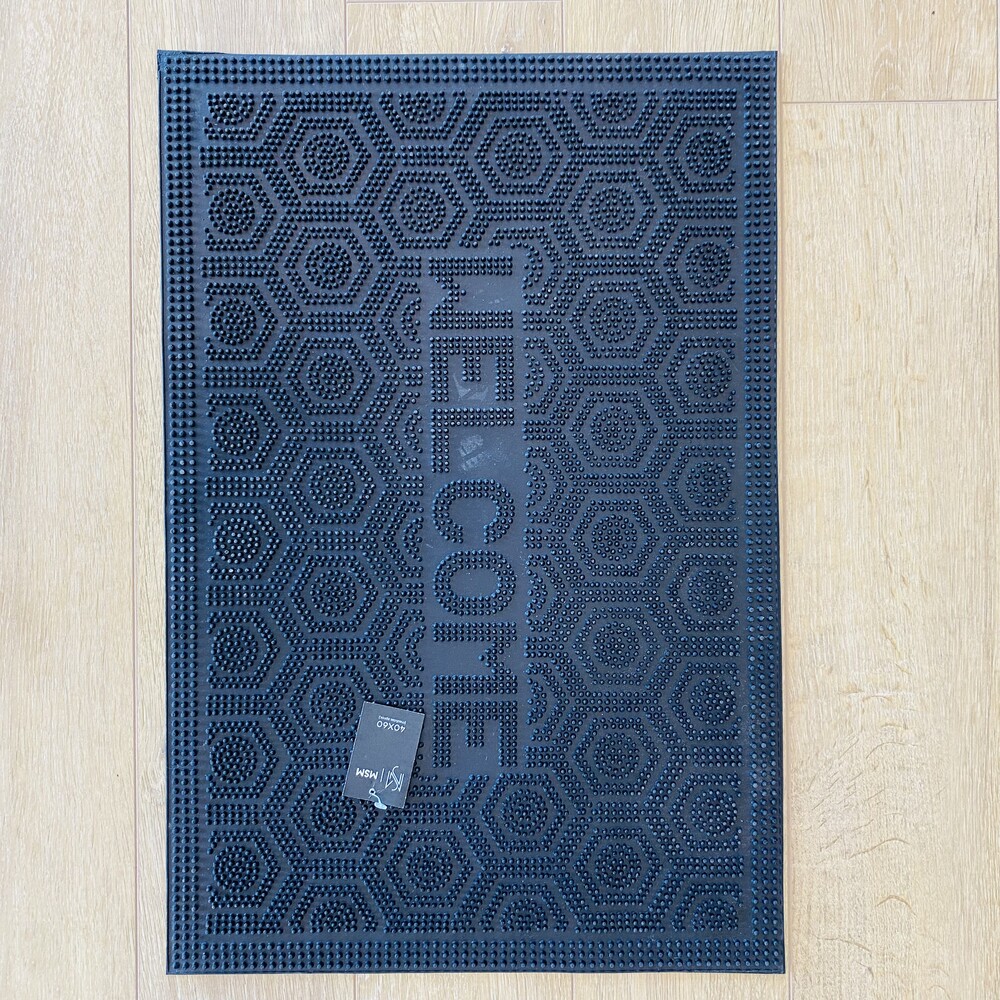 Tapete retangular azul escuro com a palavra WELCOME em relevo