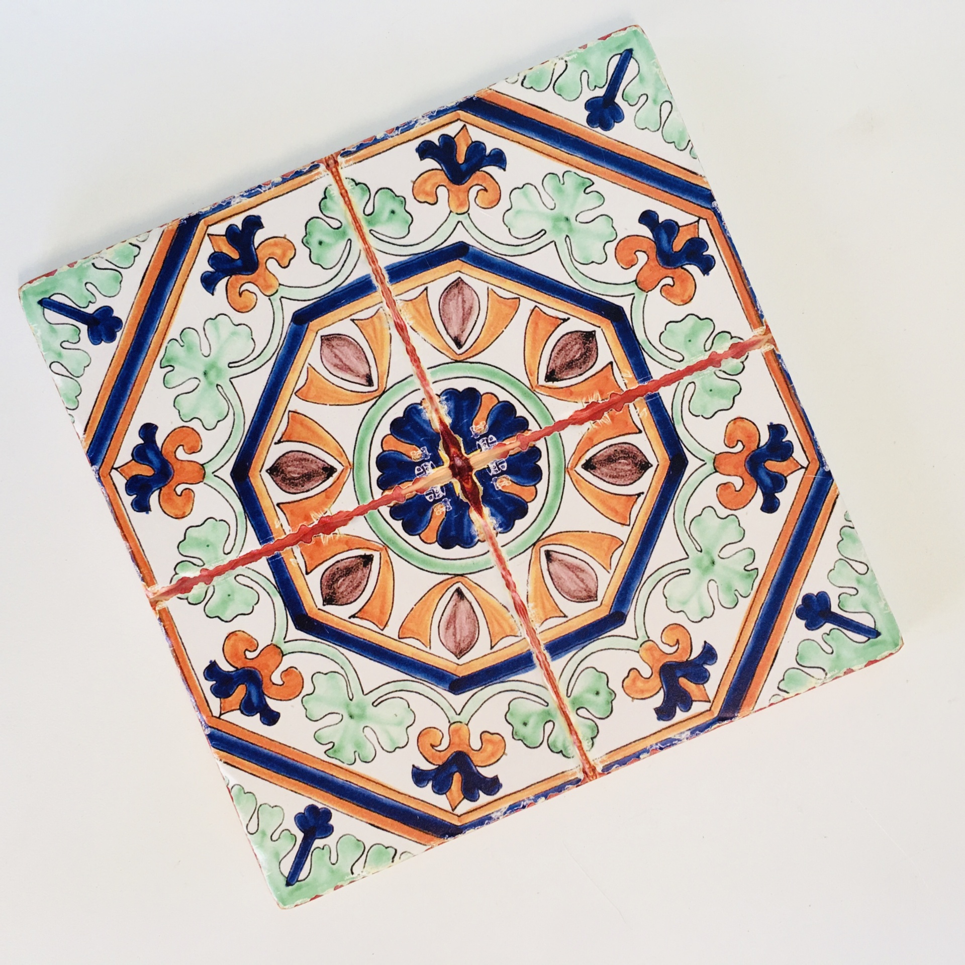 Azulejo quadrado partido com padrão geométrico e floral colorido