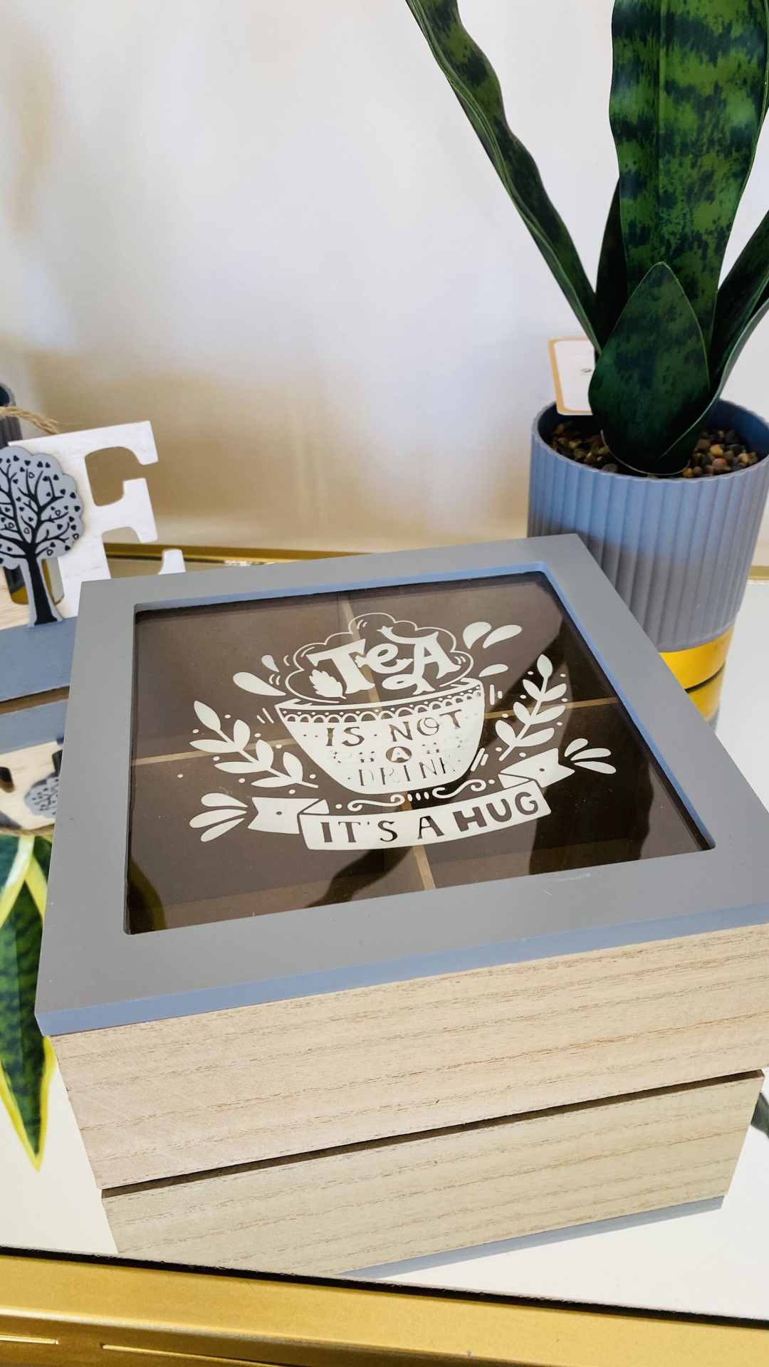 Caixa de madeira com tampa decorada e planta num vaso azul