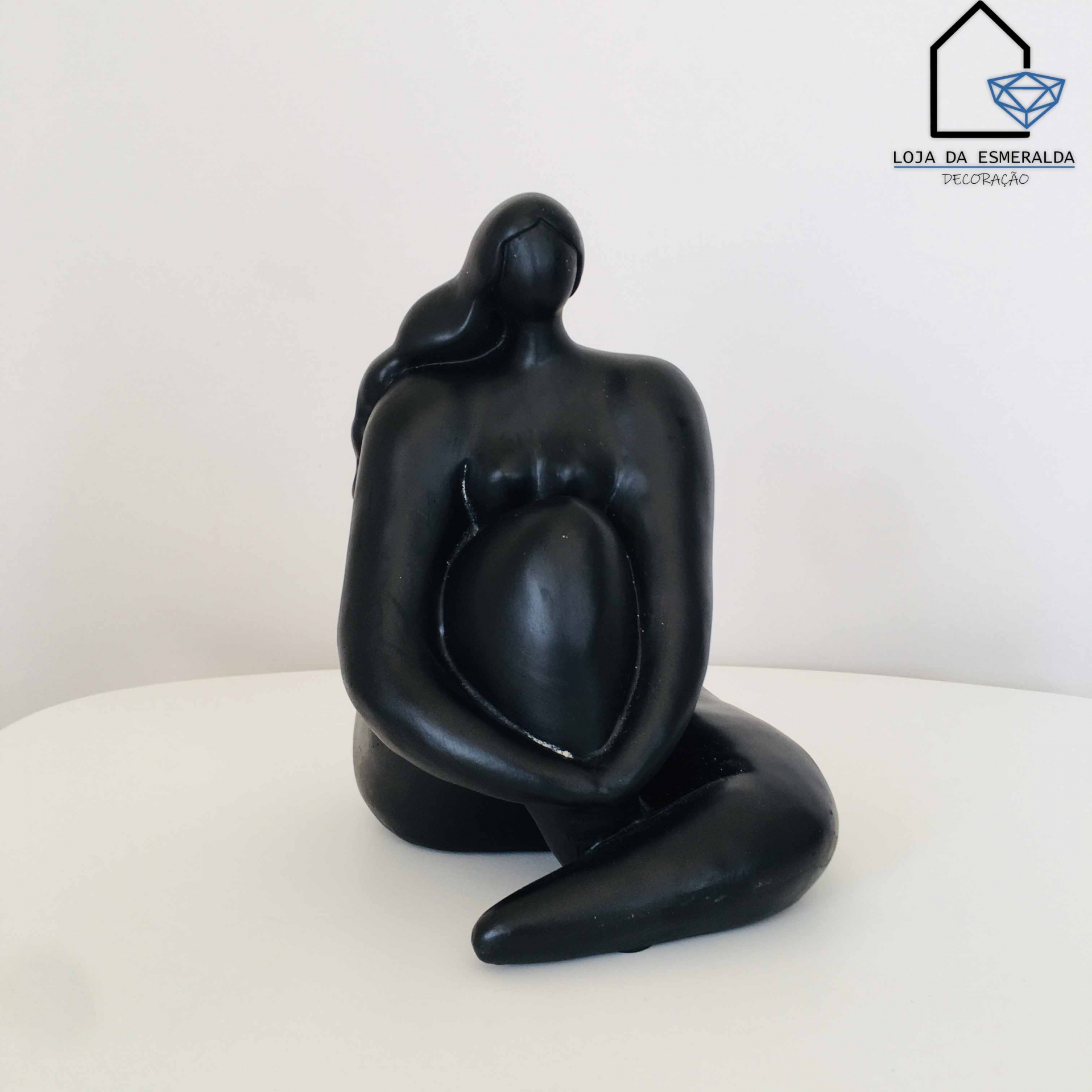 Escultura decorativa preta de figura feminina estilizada sentada