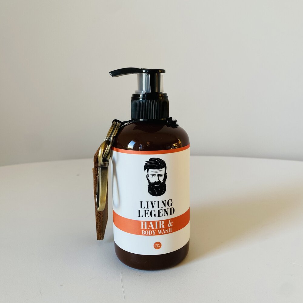 Frasco âmbar com doseador e etiqueta branca e coral de produto Living Legend Hair & Body Wash