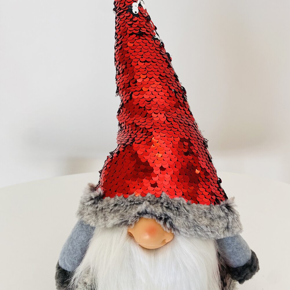 Gnomo decorativo com chapéu vermelho de lantejoulas e barbas brancas.