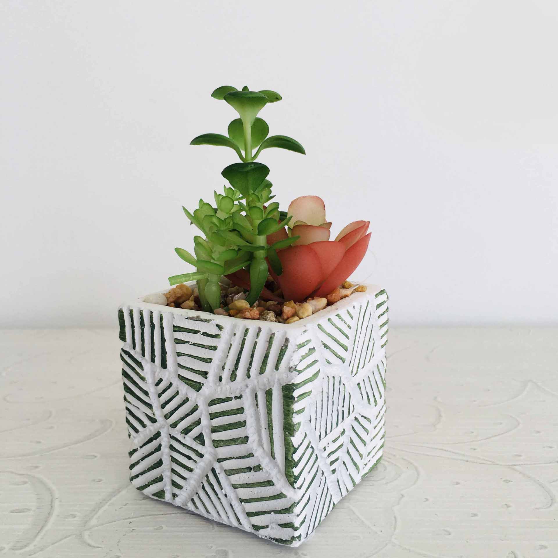 Vaso cúbico em cerâmica branca com padrão verde e suculentas artificiais
