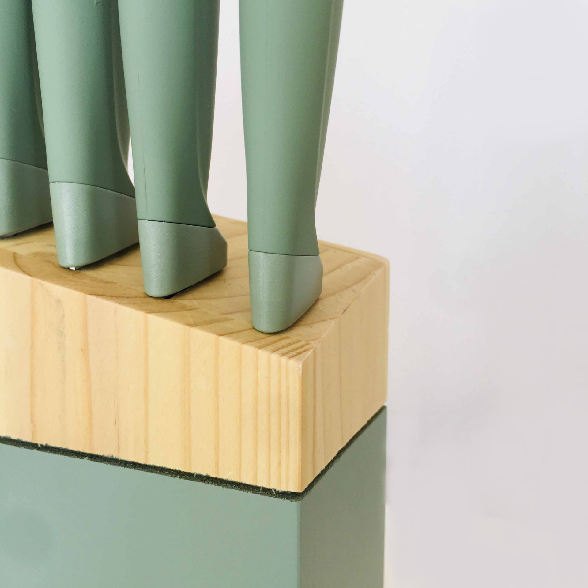 Suporte de facas em madeira clara com facas de cabos verdes