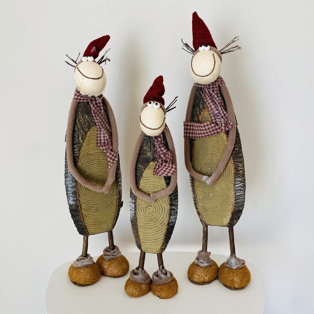 Três bonecos decorativos em madeira e metal com gorro vermelho e cachecol xadrez.