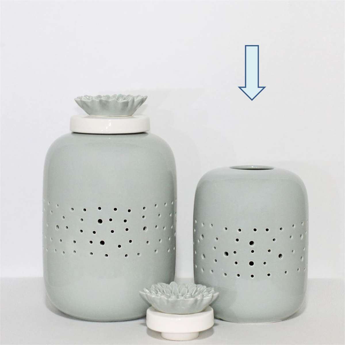 Dois frascos decorativos cinza claro com tampas florais brancas