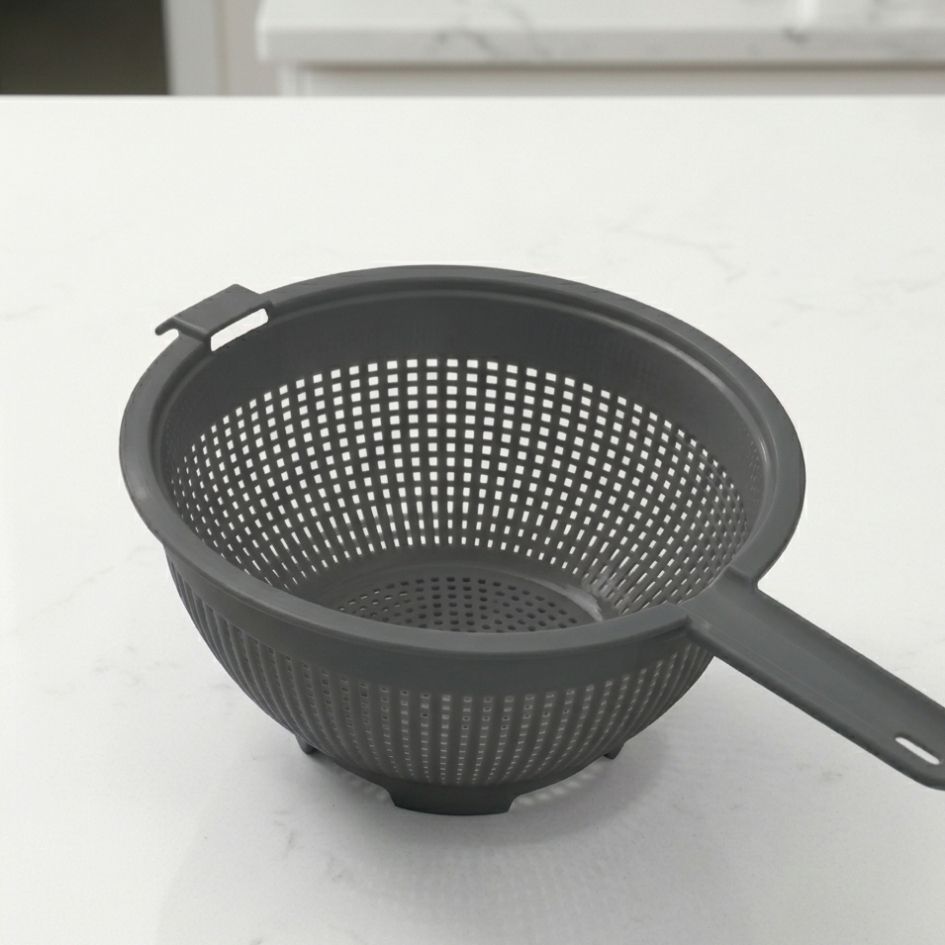 Escorredor de plástico cinza com alça e perfurações quadradas