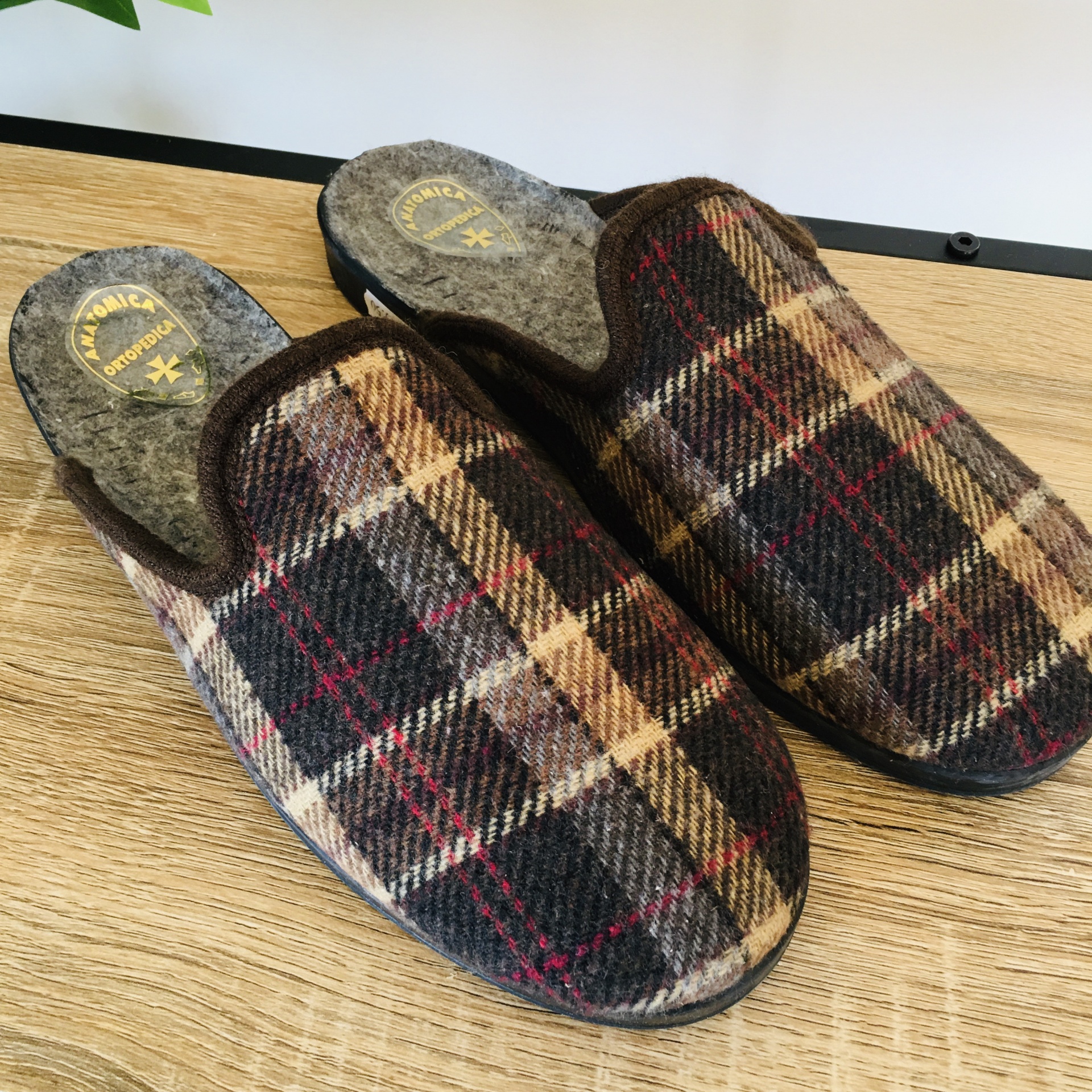 Chinelos de padrão xadrez castanho, bege e vermelho com sola preta e interior cinzento