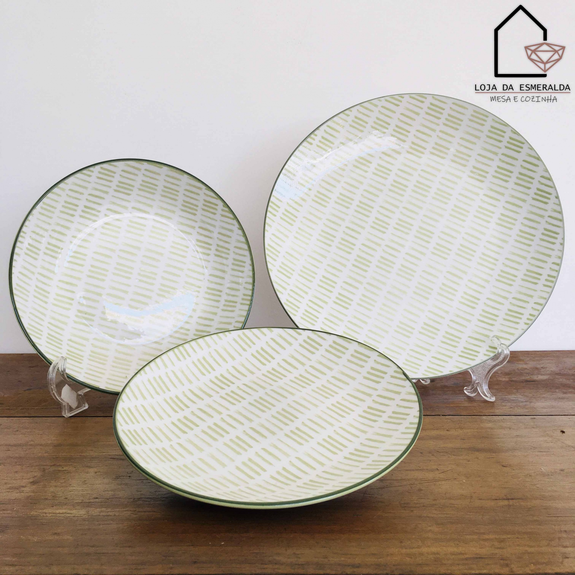 Conjunto de pratos de cerâmica com padrão verde e borda verde sobre madeira