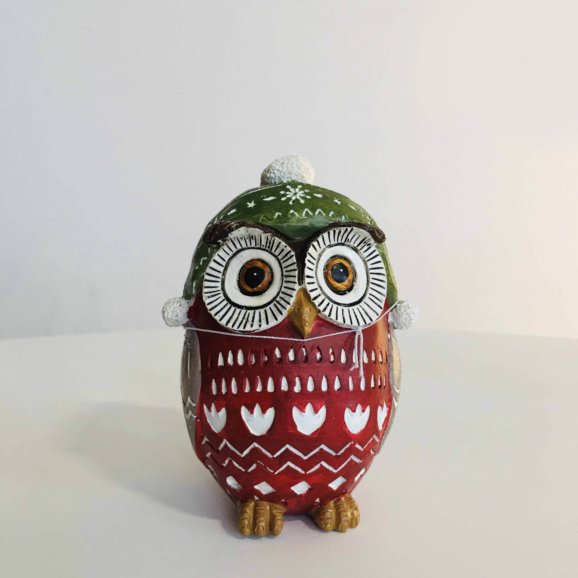 Figura decorativa de coruja pintada em madeira com gorro verde e corpo vermelho