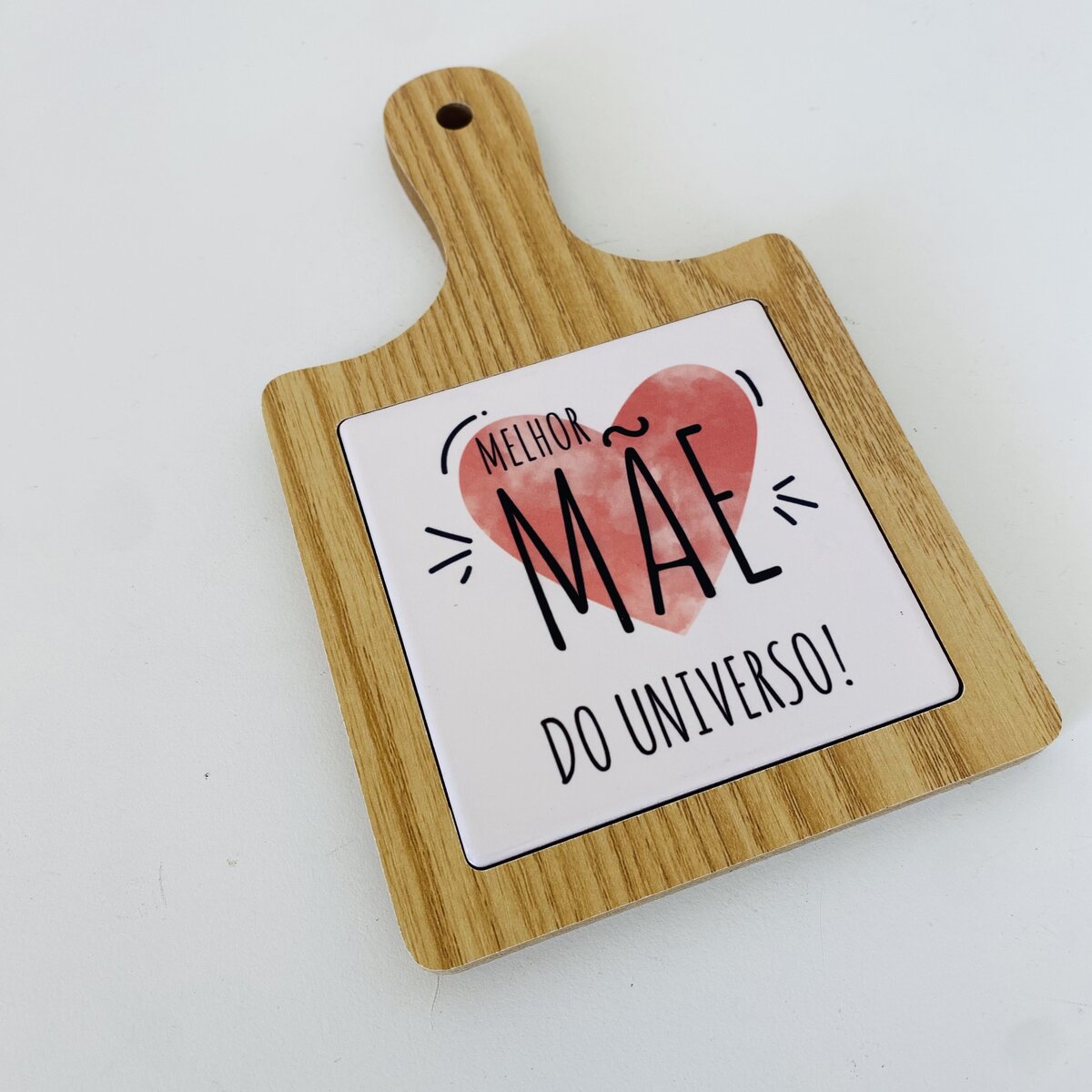 Táboa de madeira clara com azulejo branco e texto para mãe