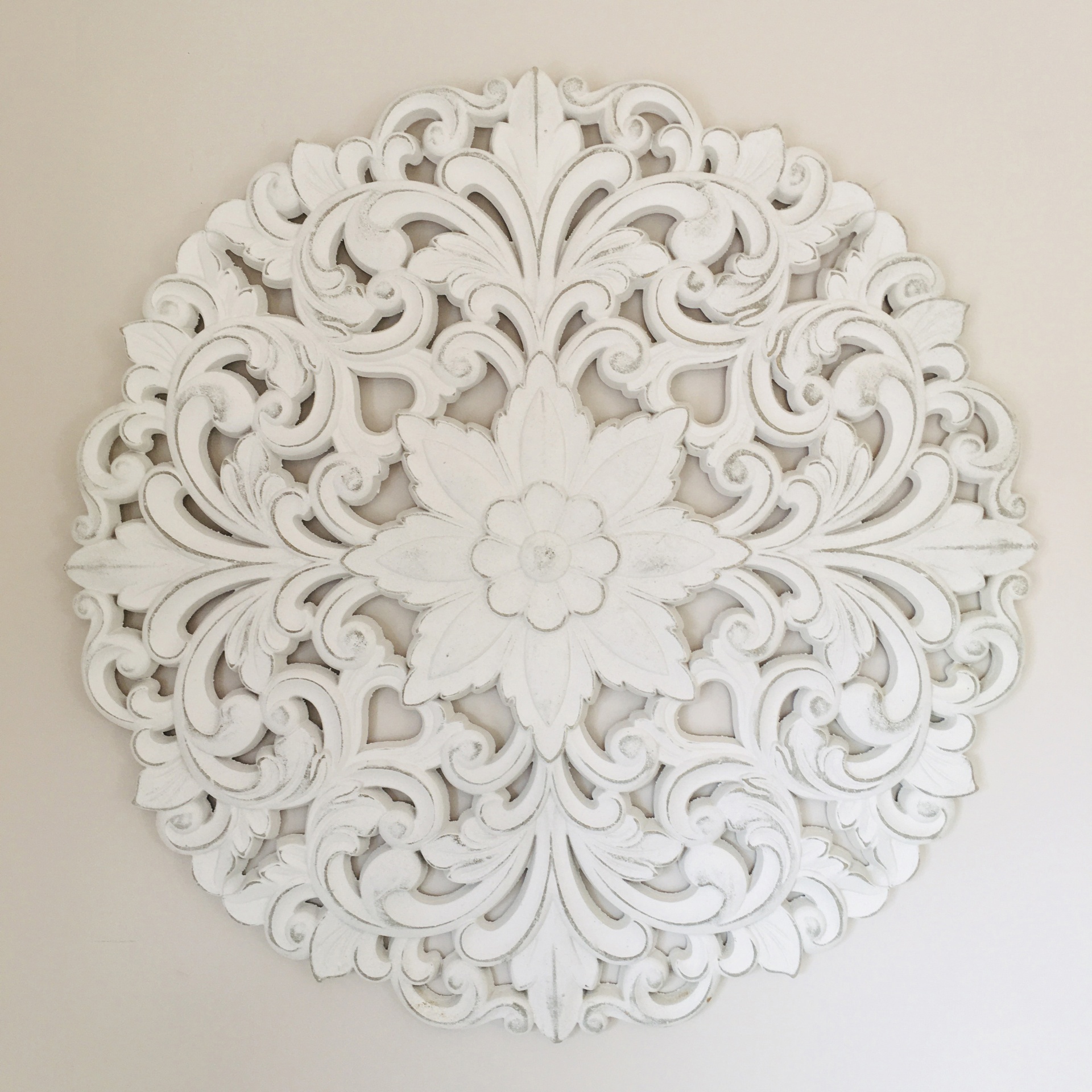 Mandala decorativa branca em madeira com padrão floral e arabescos