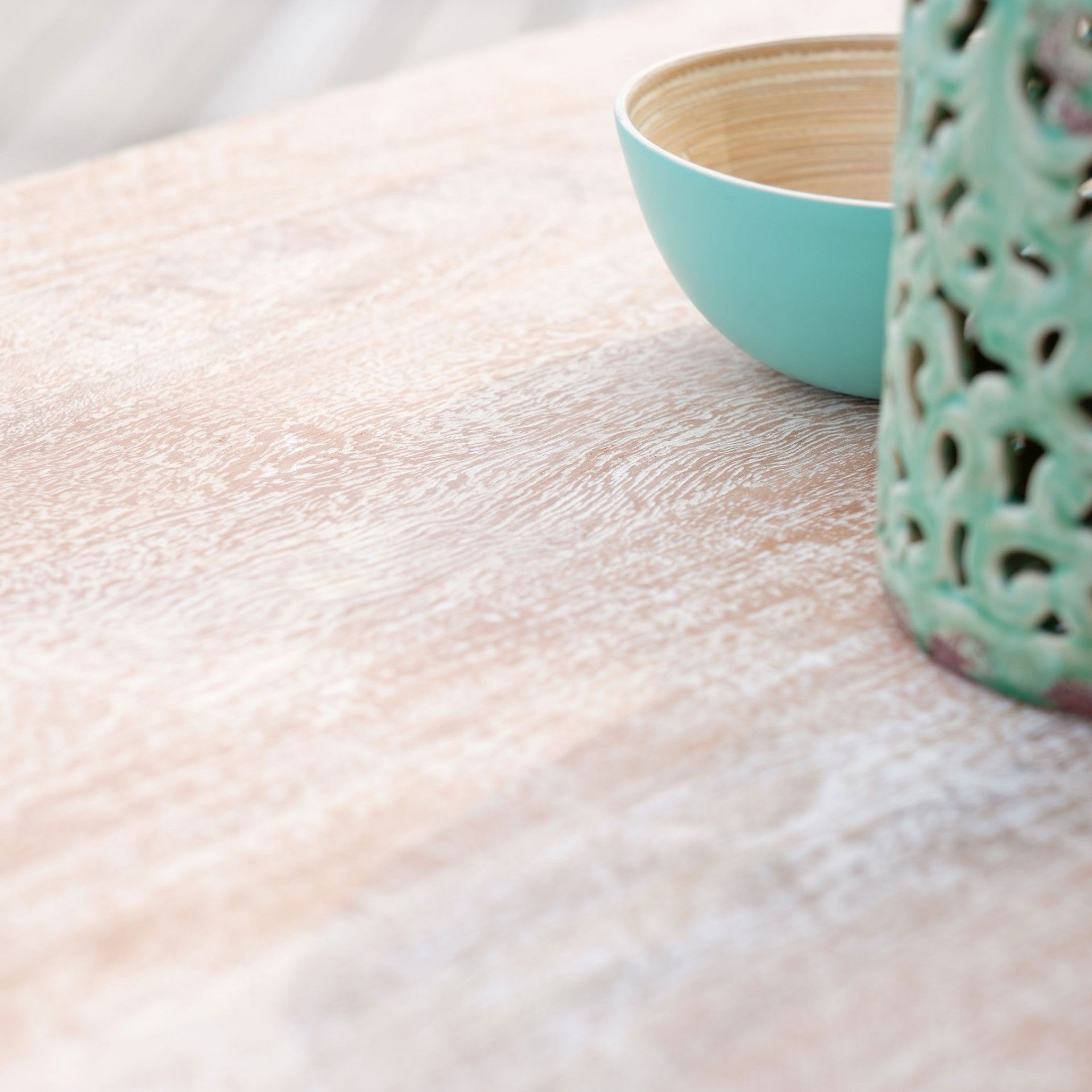 Tigela azul claro com interior de madeira e objeto decorativo verde sobre superfície de madeira texturada