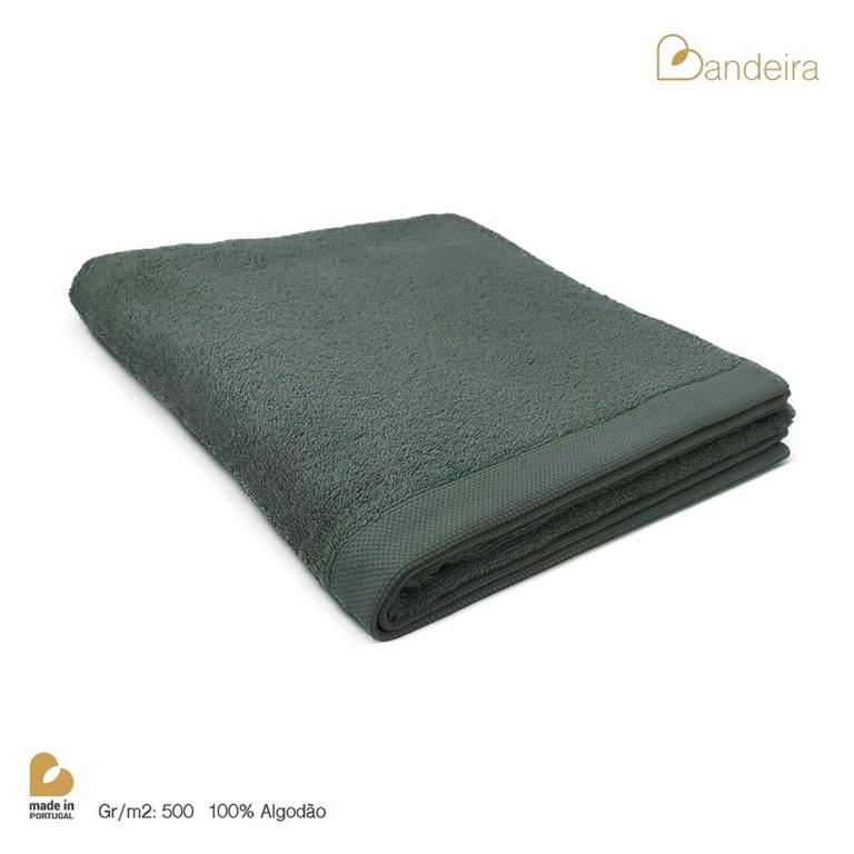 Toalha verde escura de algodão dobrada sobre fundo branco