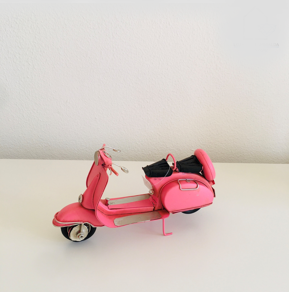 Miniatura de mota vespa cor-de-rosa com assento preto