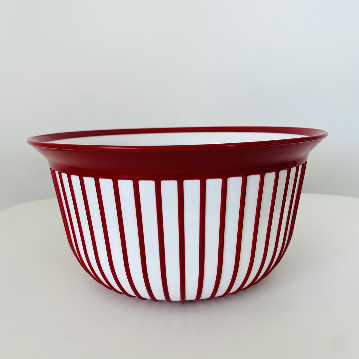 Taça de plástico branca com riscas vermelhas e borda vermelha