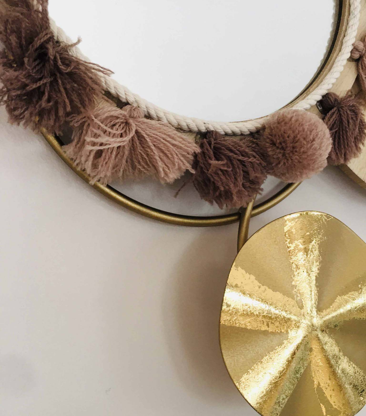 Espelho redondo com moldura dourada e franjas de lã castanha