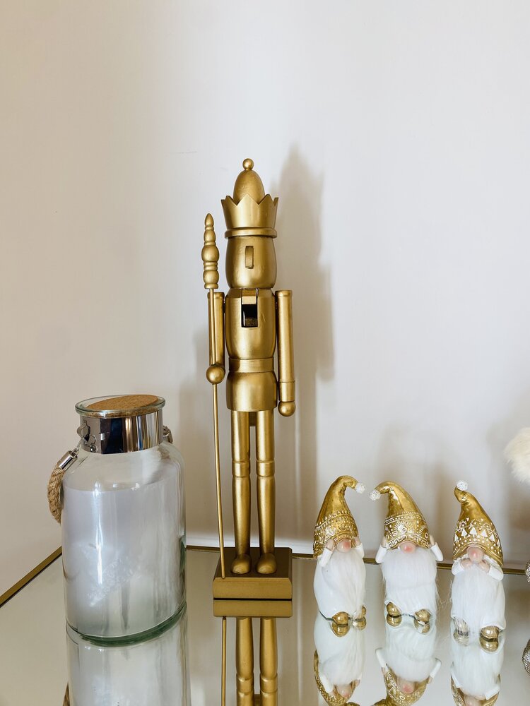 Estátua dourada de soldado de natal, três duendes pequenos dourados, frasco de vidro com tampa metálica sobre espelho