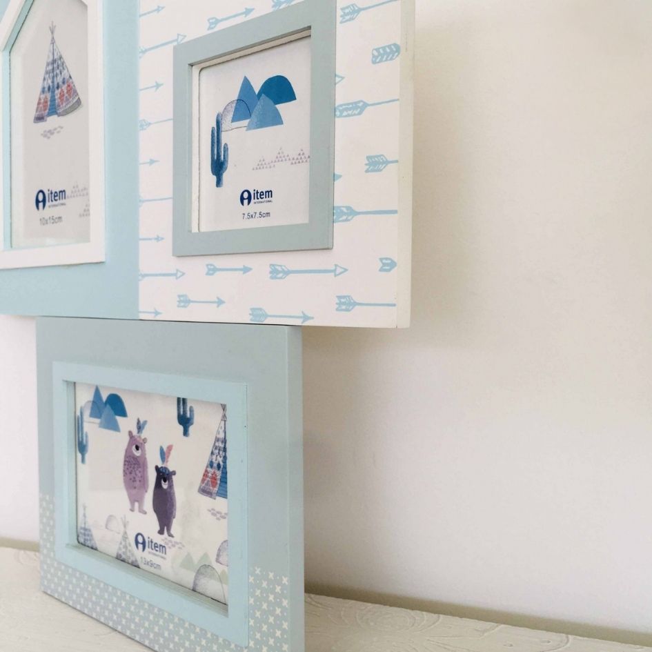 Molduras azuis e brancas com desenhos infantis penduradas numa parede clara