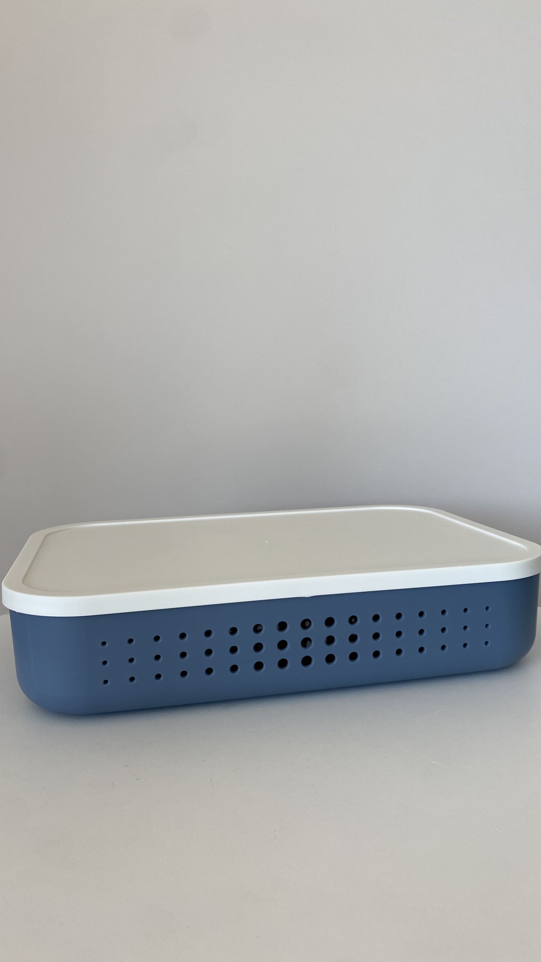 Caixa de plástico azul com tampa branca e orifícios de ventilação