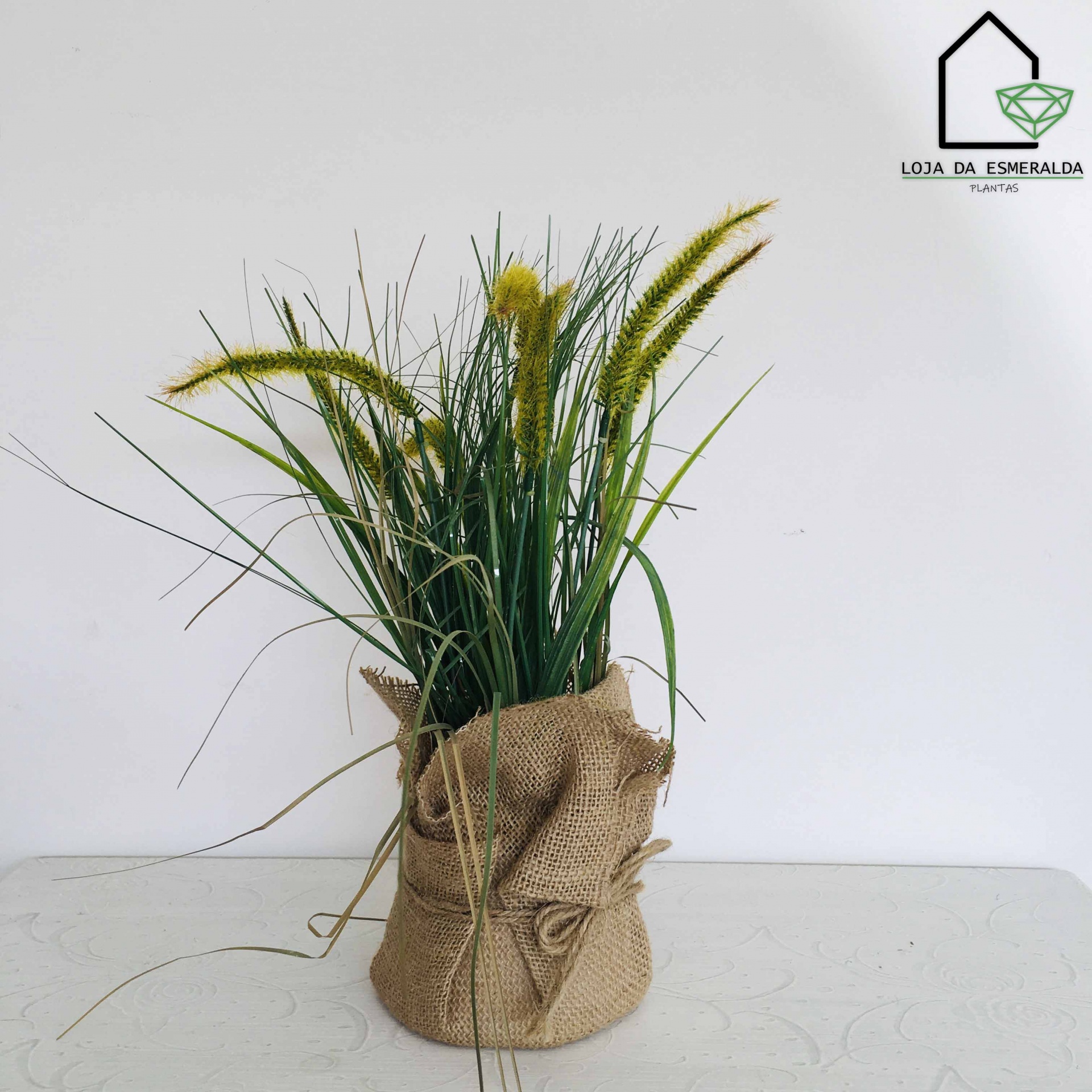 Arranjo artificial em vaso com tecido de juta e planta verde e amarela