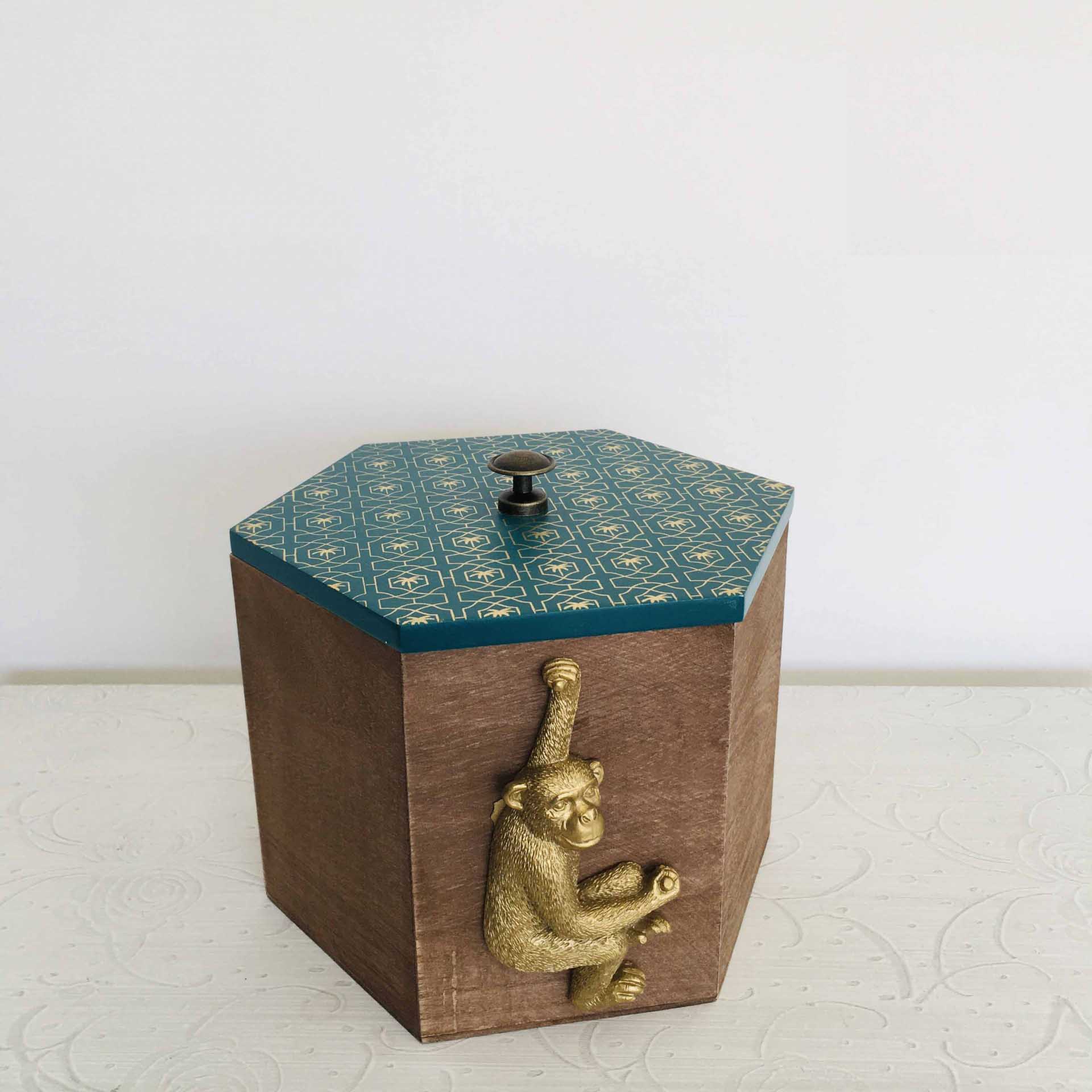 Caixa hexagonal de madeira com tampa azul e figura de macaco dourado