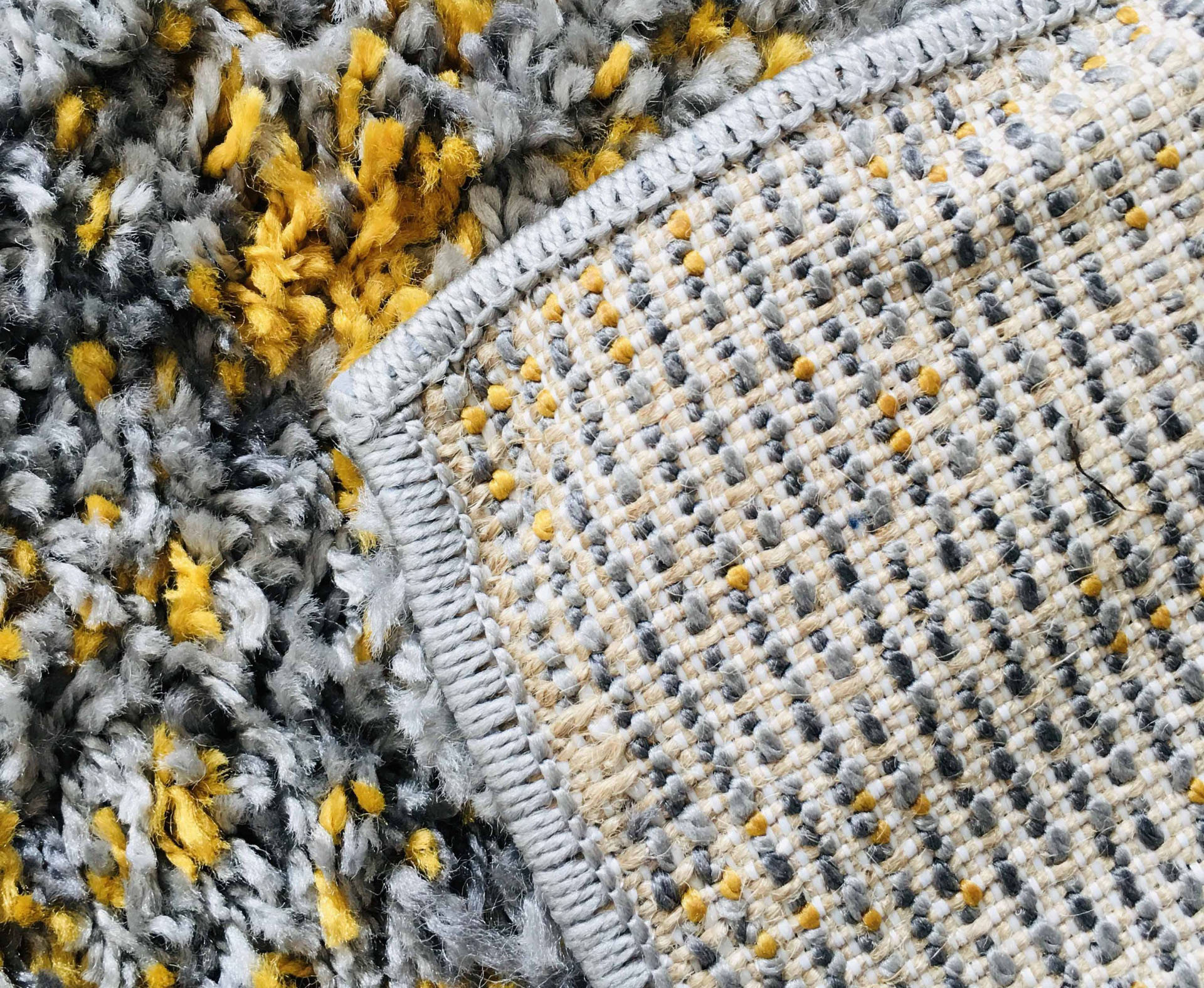 Dois tapetes com texturas e cores cinza, amarelo e branco overlapped.