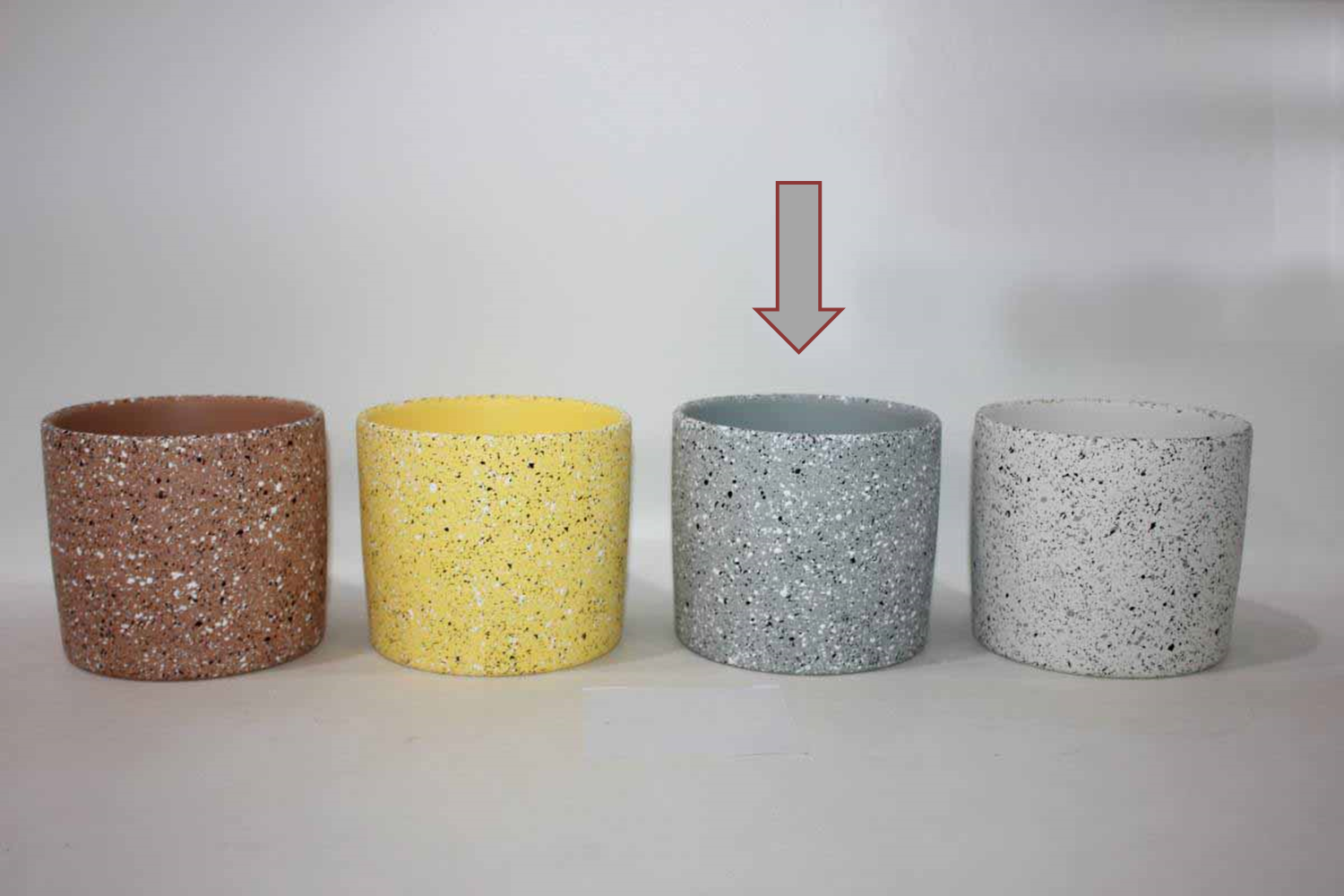 Quatro vasos cilíndricos coloridos com textura pontilhada em fundo branco